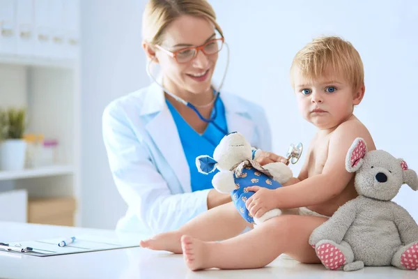 La doctora está escuchando a un niño con un estetoscopio en la clínica — Foto de Stock