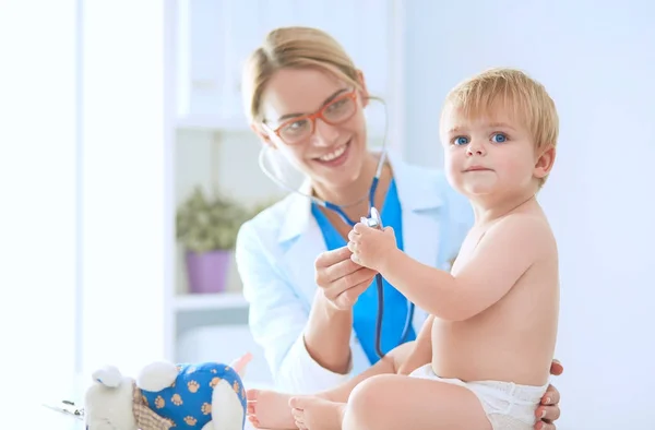 Vrouwelijke arts luistert kind met een stethoscoop in de kliniek — Stockfoto