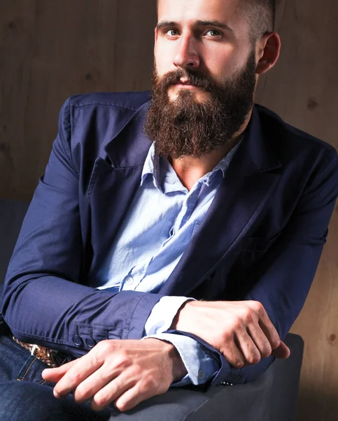 Geschäftsmann auf dem Sofa in der Büro-Lobby, isoliert auf dunklem Hintergrund — Stockfoto