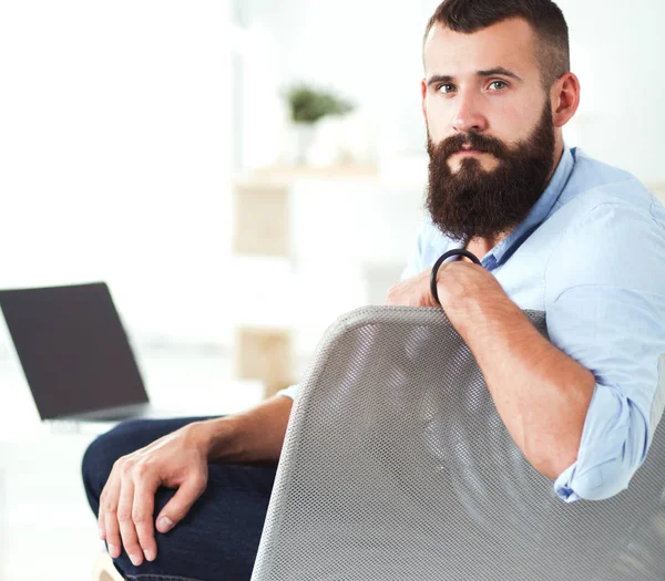 Młody przedsiębiorca siedzi na krześle w biurze — Zdjęcie stockowe