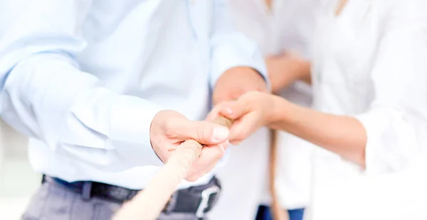 Konzeptbild eines Geschäftsteams, das ein Seil als Element der Teamarbeit im Vordergrund verwendet — Stockfoto