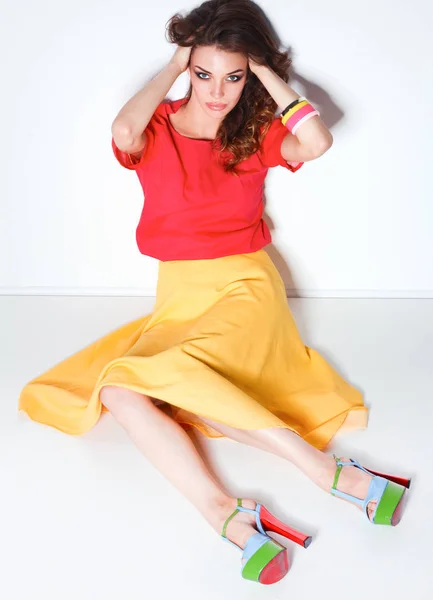 Young woman sitting on the floor, isolated in white background — Stock Photo, Image