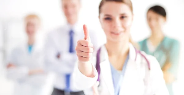 Attraktive Ärztin vor medizinischer Gruppe zeigt OK — Stockfoto