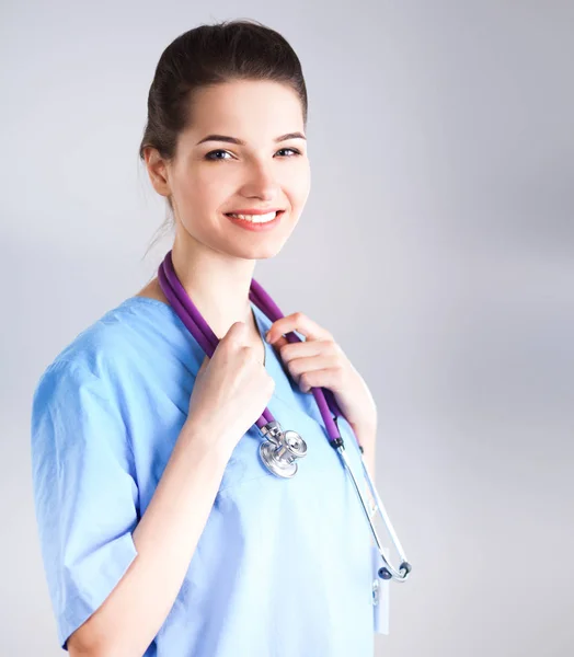Usmívající se doktorka v uniformě stojící v nemocnici — Stock fotografie