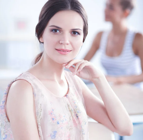 Aantrekkelijke zakenvrouw zit op het bureau in het kantoor — Stockfoto