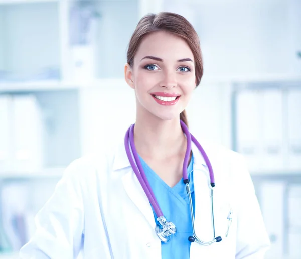 Porträtt av ung kvinna läkare med vit rock stående på sjukhus Royaltyfria Stockbilder