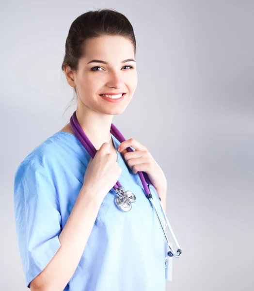 Smiling female doctor in uniform standing at hospital Stock Image