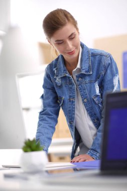 Masanın yanında duran iki genç kadın enstrüman, plan ve dizüstü bilgisayarla.