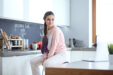 Mutfakta masada oturan genç kadın.