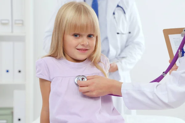 Female doctor examining child with stethoscope at surgery — Stock Photo, Image