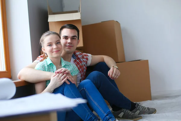 Пара переезжающих в дом сидящих на полу. Пара — стоковое фото