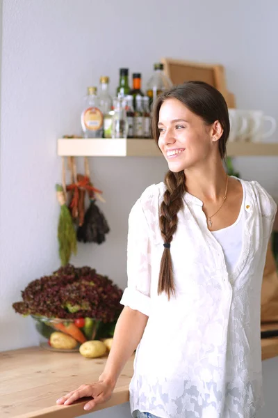 Mujer joven de pie cerca de escritorio en la cocina. Mujer joven . —  Fotos de Stock