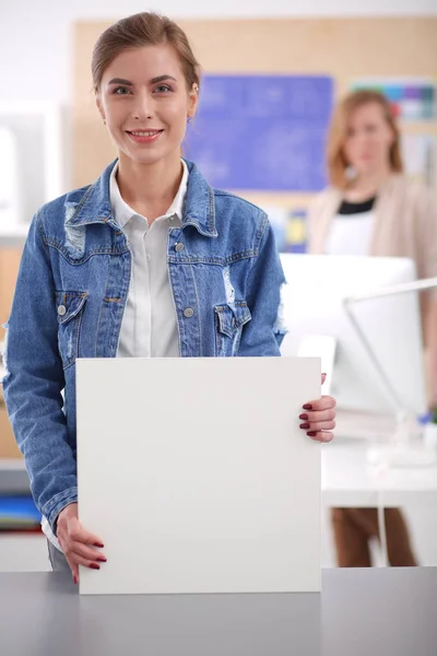 Zwei junge Frauen stehen neben Schreibtisch mit Instrumenten, Plan und Laptop. — Stockfoto