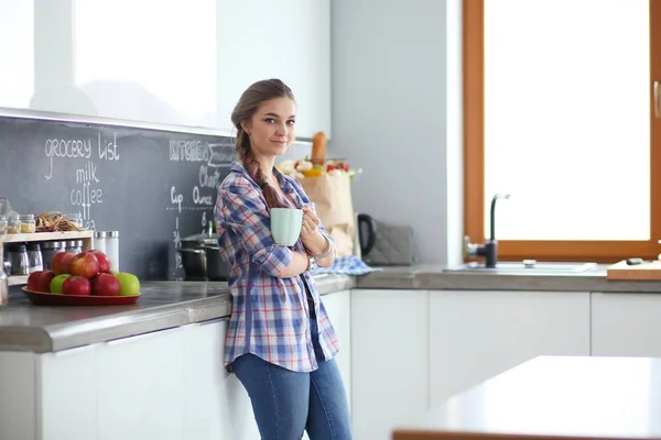 Mujer feliz bebiendo té en la cocina en casa . — Foto de Stock