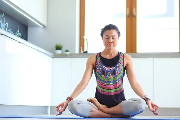 Mujer joven haciendo yoga en casa en la posición de loto. Yoga. Una mujer. Estilo de vida — Foto de Stock