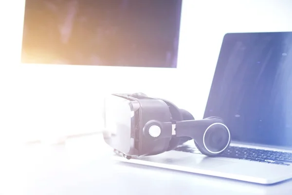 虚拟现实的护目镜与笔记本电脑放在桌上。生意。3d技术 — 图库照片