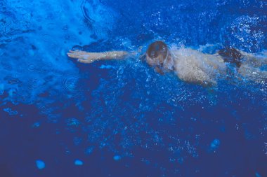 Yüzme havuzunda erkek yüzücü. Su altı fotoğrafı. Erkek yüzücü.