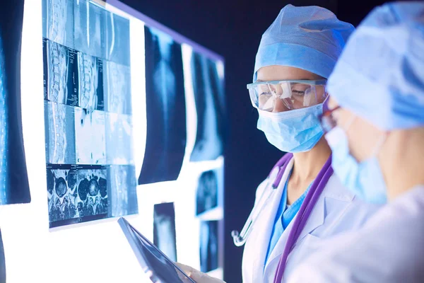 Twee vrouwelijke artsen die röntgenfoto 's bekijken in een ziekenhuis — Stockfoto