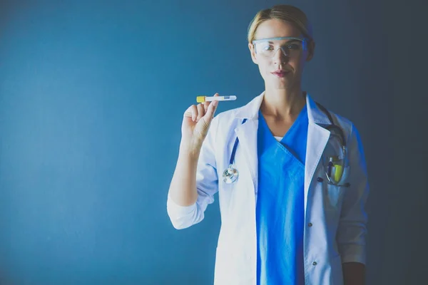 Female medical or research scientist or doctor using looking at a test tube of clear solution in a lab or laboratory — Stock Photo, Image