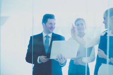 Grup iş adamları toplantı sırasında dizüstü bilgisayar ile sunum yapıyor. Grup iş adamları
