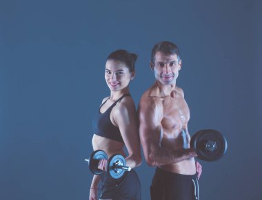 Atletik erkek ve kadın ile bir dumbells. Kişisel fitness eğitmeni. Kişisel eğitim.