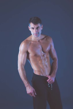 kaslı adam. Kaslı adam kas gösterilen gri arka plan üzerinde. Fitness Eğitmeni. Fitness profesyonel. Egzersiz. Mens fitness.