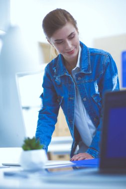 Masanın yanında duran iki genç kadın enstrüman, plan ve dizüstü bilgisayarla.