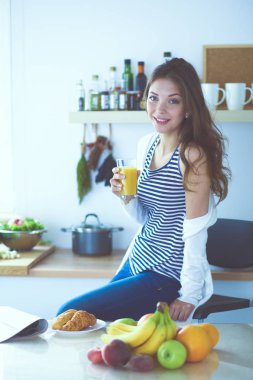 Mutfakta masanın yanında duran genç bir kadın. Genç kadın. .