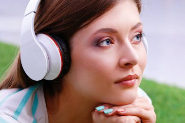 Yeşil çimlerde oturan genç bir kadın. Portreit genç bayan