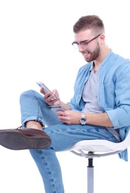 Sandalyede oturan ve cep telefonuyla genç adam. Startupper. Genç girişimci.