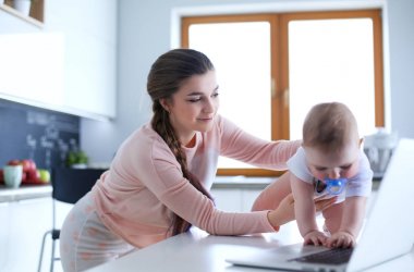 Annesi bebeğini evde parlak mutfakta ile.