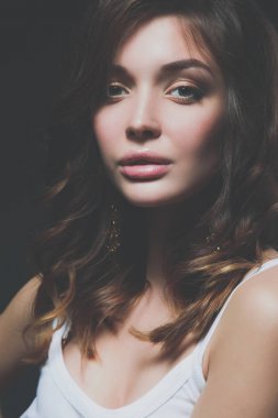 güzel genç kadın yüz portresi. koyu arka plan üzerinde izole.