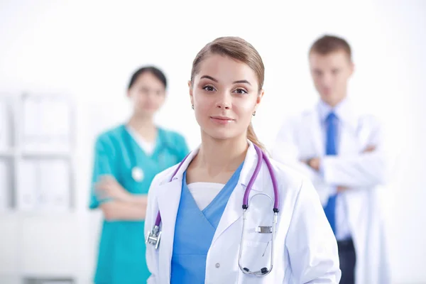 Attractive female doctor in front of medical group. — Stock Photo, Image