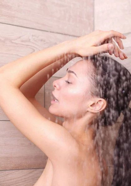 Junge schöne Frau unter der Dusche im Badezimmer. — Stockfoto