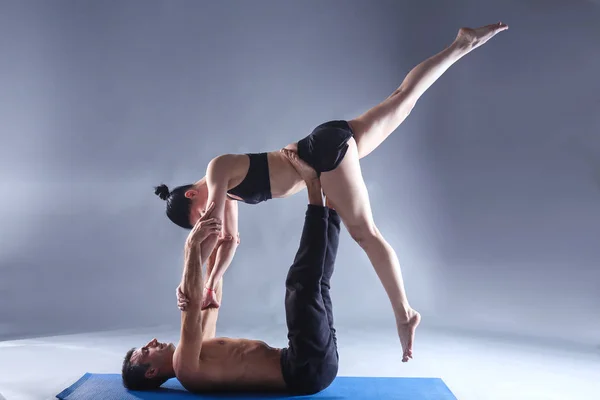 Jong koppel acro yoga beoefenen op mat samen in de studio. Acroyoga. Paar yoga. Partner yoga. — Stockfoto