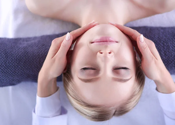 Mujer joven acostada en una mesa de masaje, relajándose con los ojos cerrados. Una mujer. Salón de spa — Foto de Stock