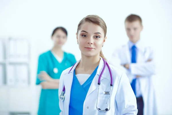Attractive female doctor in front of medical group. — Stock Photo, Image