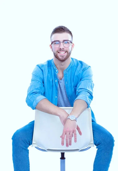 Junger Mann sitzt isoliert auf dem Stuhl vor weißem Hintergrund. Startupper. Jungunternehmer. — Stockfoto