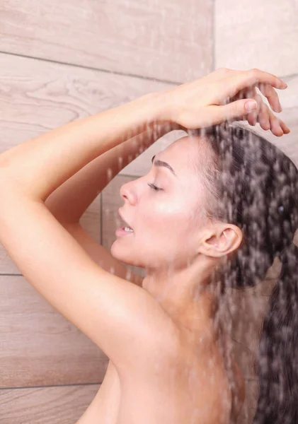 Junge schöne Frau unter der Dusche im Badezimmer. lizenzfreie Stockfotos