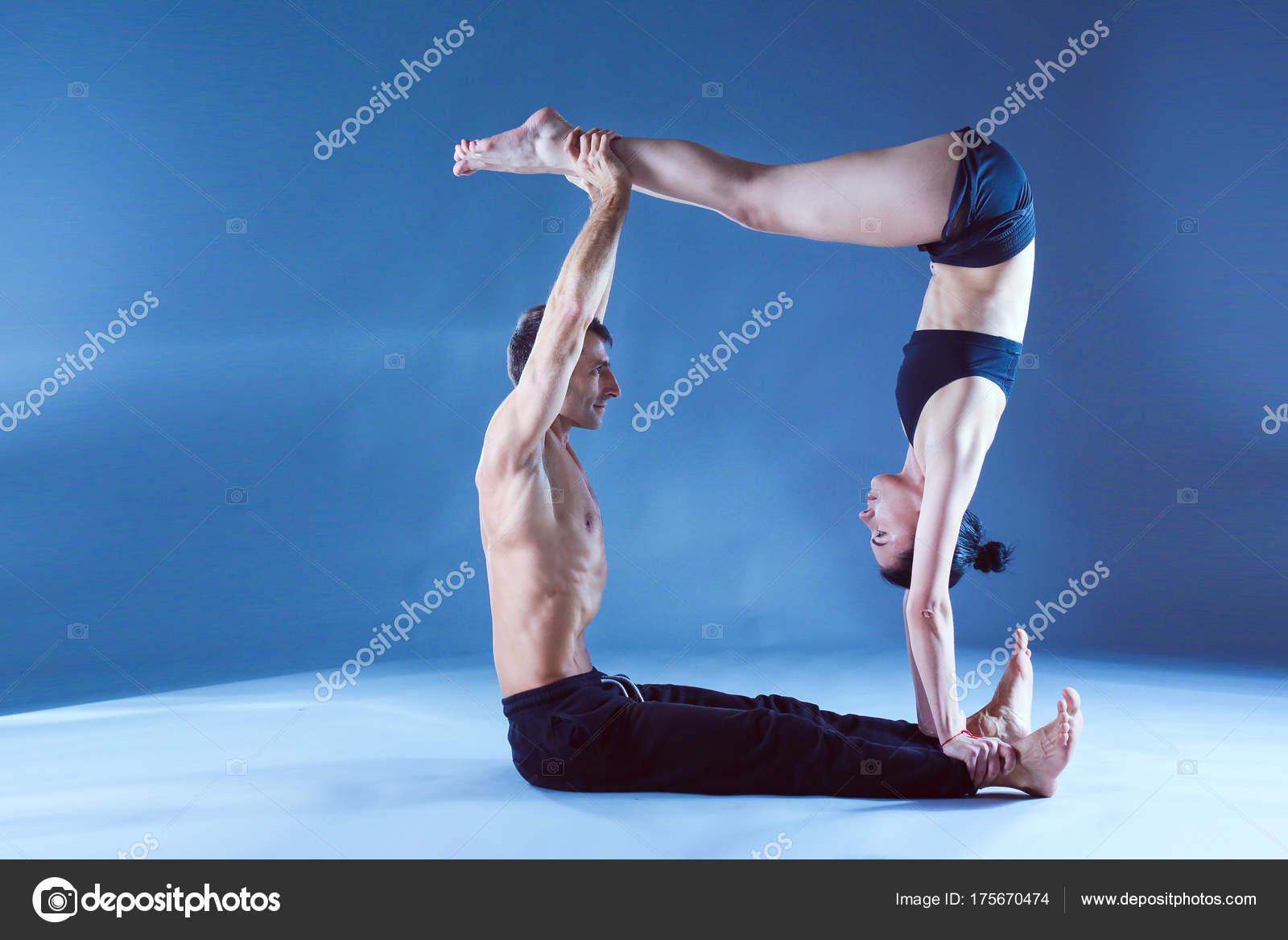 Fotografia Acro yoga, two sporty people practice yoga in pair, couple doing  stretching exer - Kup na