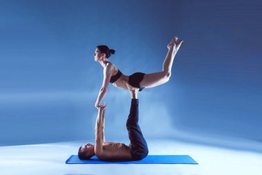 Genç çift Acro yoga mat Studio birlikte uygulamak. Acroyoga. Çift yoga. Ortak yoga.