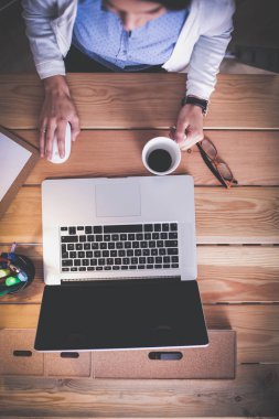 Masada oturan genç bir kadın..