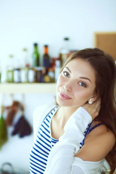 Jonge vrouw die bij een bureau in de keuken staat. Jonge vrouw . — Stockfoto