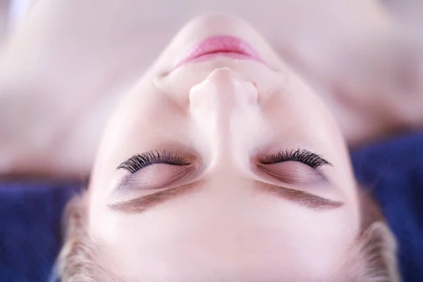 Jeune femme allongée sur une table de massage, relaxante les yeux fermés. Femme. Salon de spa — Photo