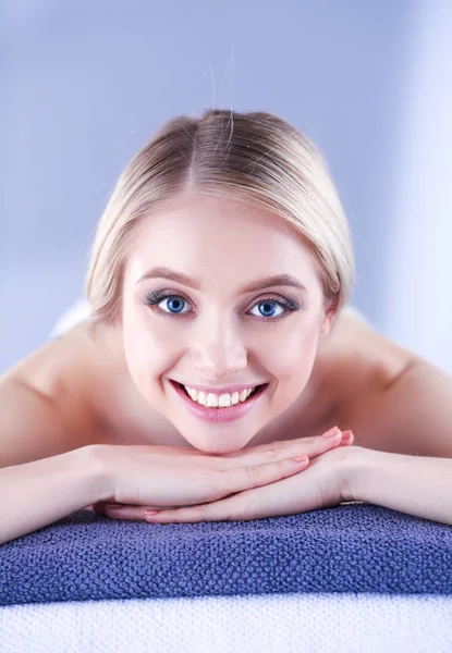Bir masaj masanın üzerinde yatan, rahatlatıcı bir genç kadın. Kadın. Spa Salonu