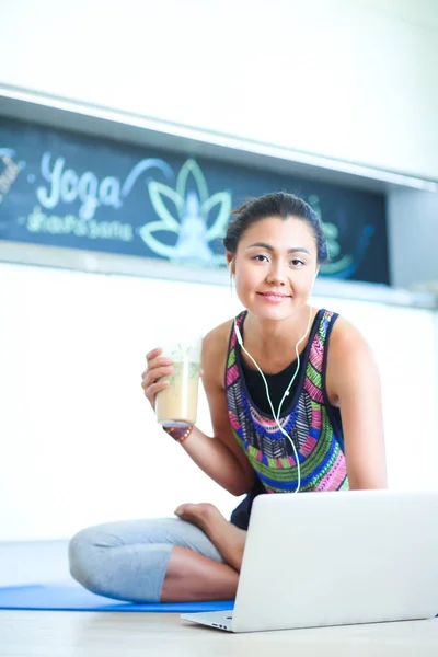 Deportiva mujer sonriente utilizando el ordenador portátil en la habitación luminosa. Una mujer. Estilo de vida — Foto de Stock