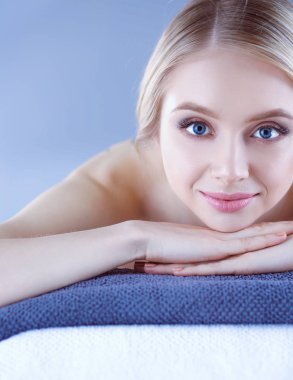 Bir masaj masanın üzerinde yatan, rahatlatıcı bir genç kadın. Kadın. Spa Salonu