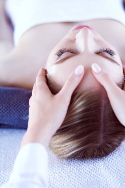 Masaj masasında uzanmış gözleri kapalı rahatlayan genç bir kadın. - Kadın. Spa salonu