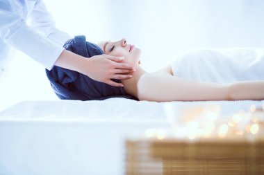 Masaj masasında uzanmış gözleri kapalı rahatlayan genç bir kadın. - Kadın. Spa salonu