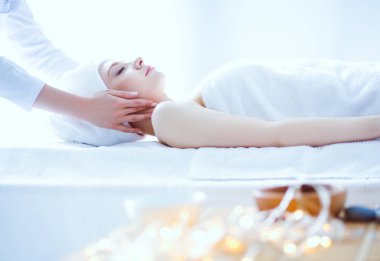 Masaj masasında uzanmış gözleri kapalı rahatlayan genç bir kadın. - Kadın. Spa salonu